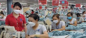 Gai, in red, is instructing the workers at the sewing line